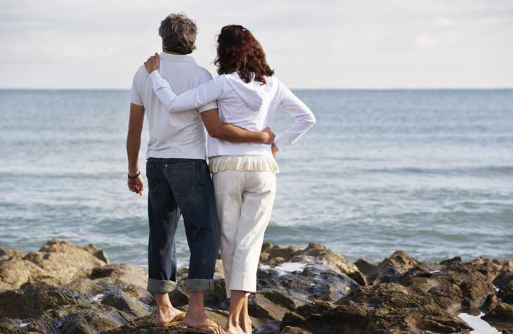 woman with dyspurenia overlooking ocean with husband
